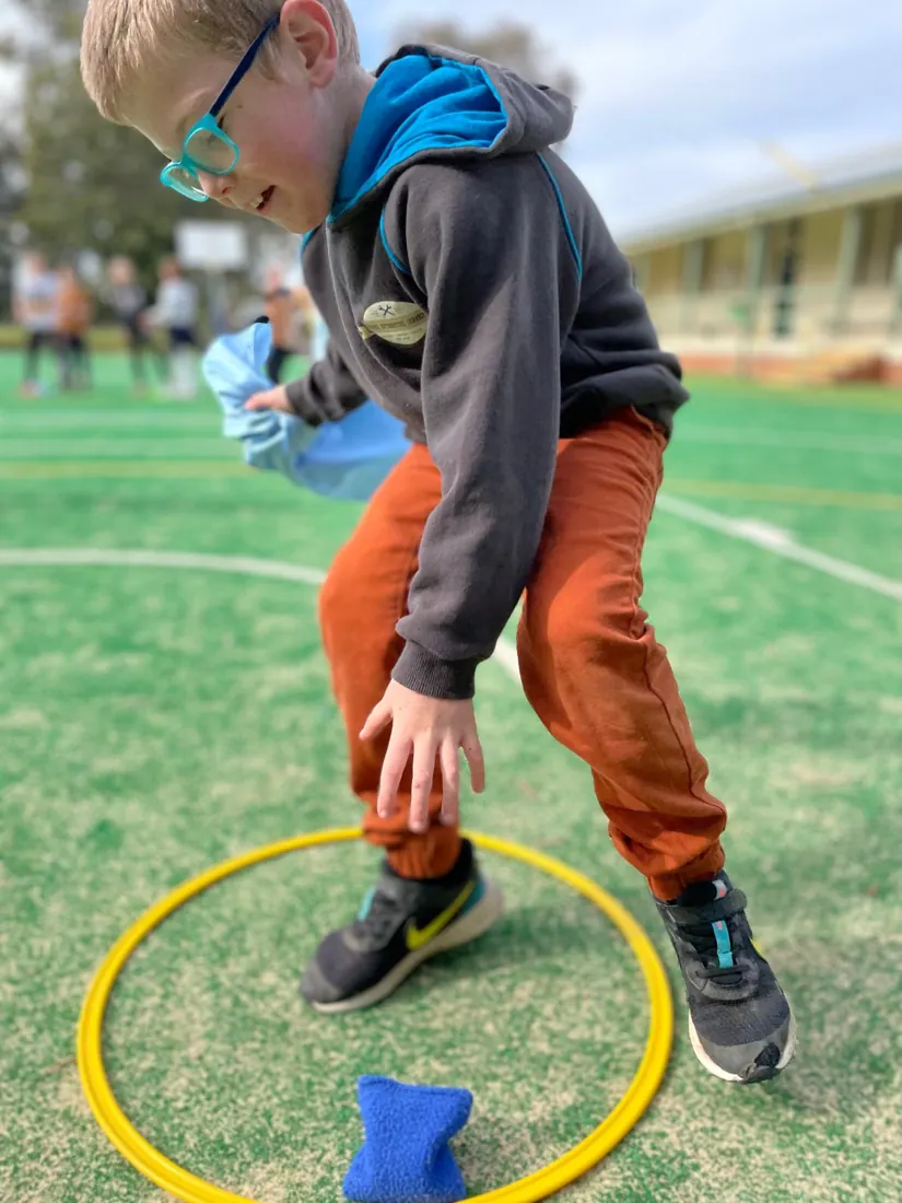 Child taking part in a beanbag and hoop activity